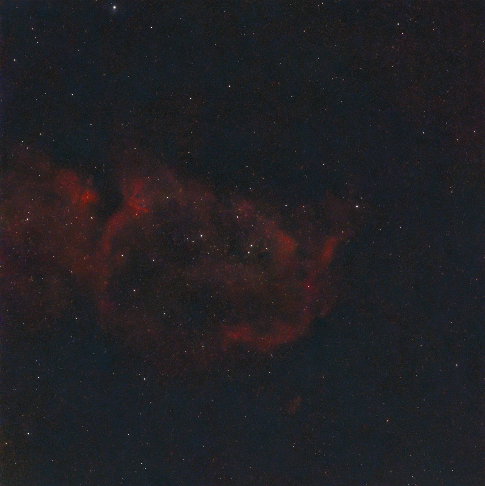 The red emission clouds and dark cavities of the Soul Nebula