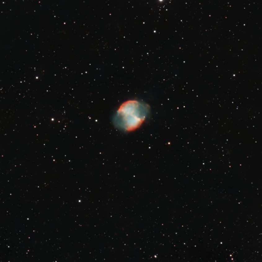 The Dumbbell Nebula, Messier 27, glowing among a dense field of stars